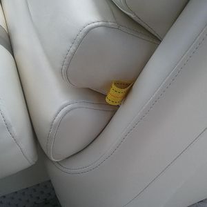 Grab strap for lounge seats with trash can under headrest